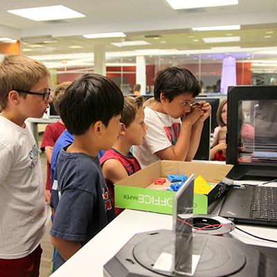 Photo of kids looking at a 3d printer