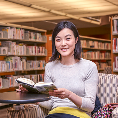 Eriko Yamamoto reading a book from the library's World Languages collection