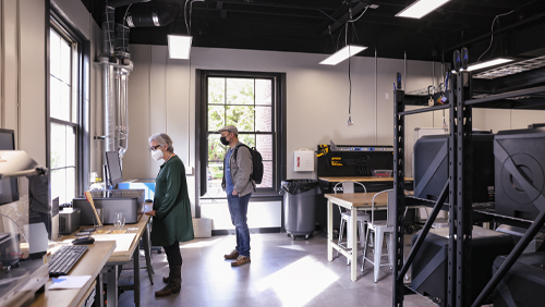 A Makerplace employee helping a patron with the laser cutter