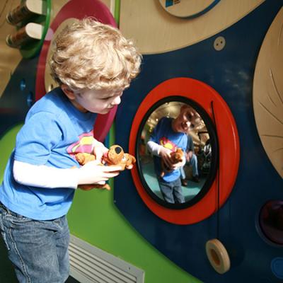 boy playing with wall-mounted toys