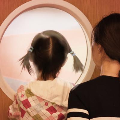 Child and Mother looking through round oindow