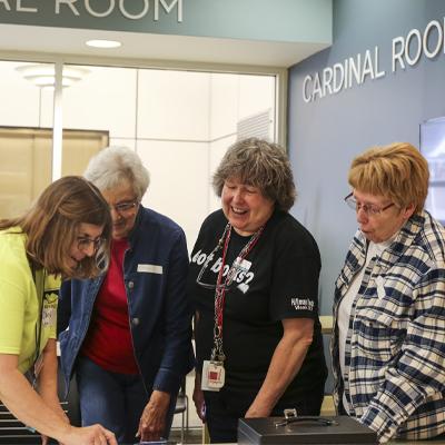 Friends of the library members laughing together at a book sale