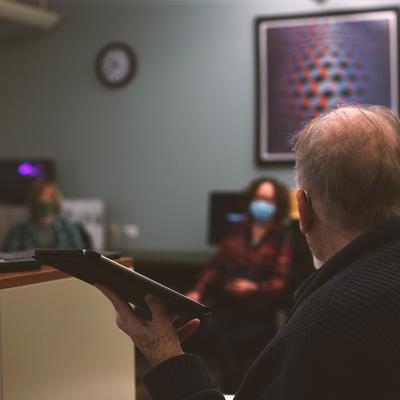 A volunteer teaching students about ipads in the senior center computer room